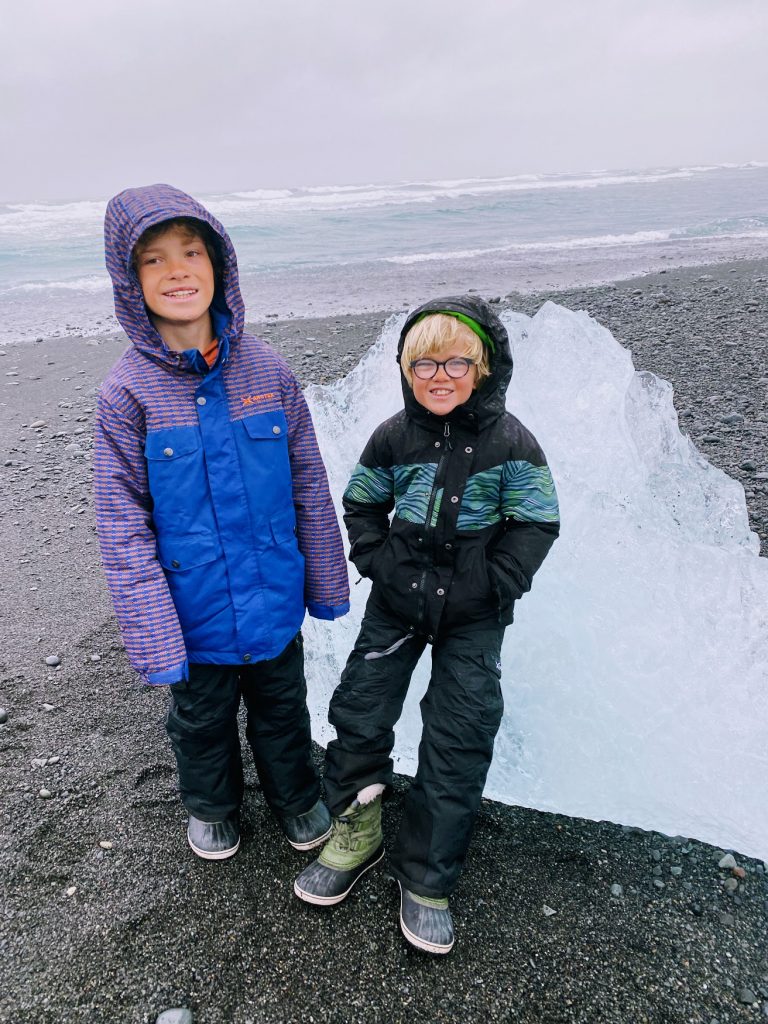 Kids in front of a diamond on Diamond Beach, Iceland.