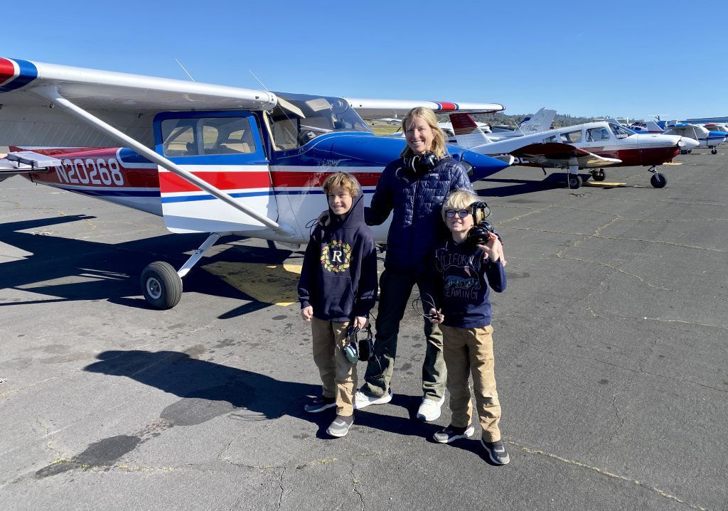 The kids in front of a Cessna before taking off. 